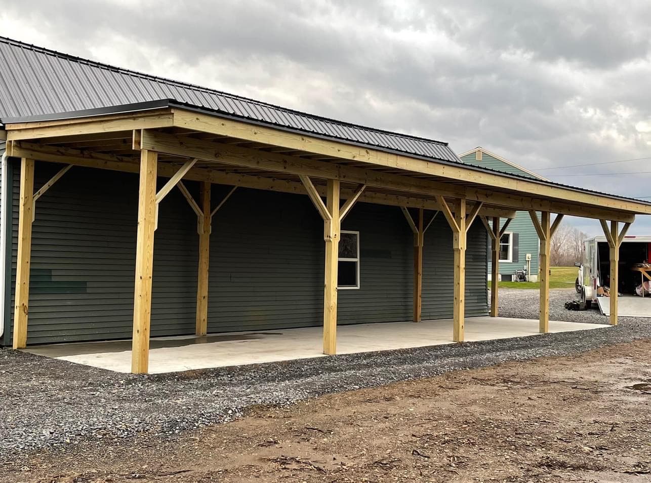 Covered porch addition with timber post and beam construction and metal roof
