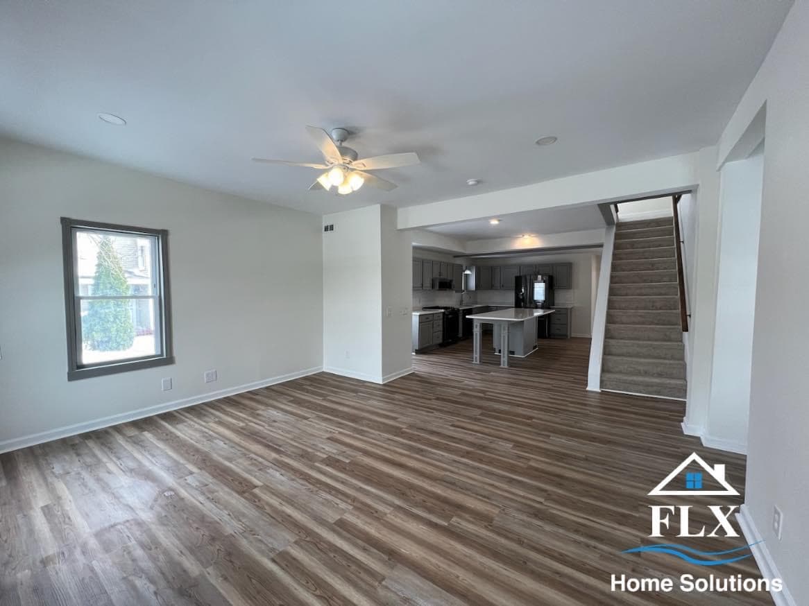 Open concept living room addition with wood flooring and view to kitchen