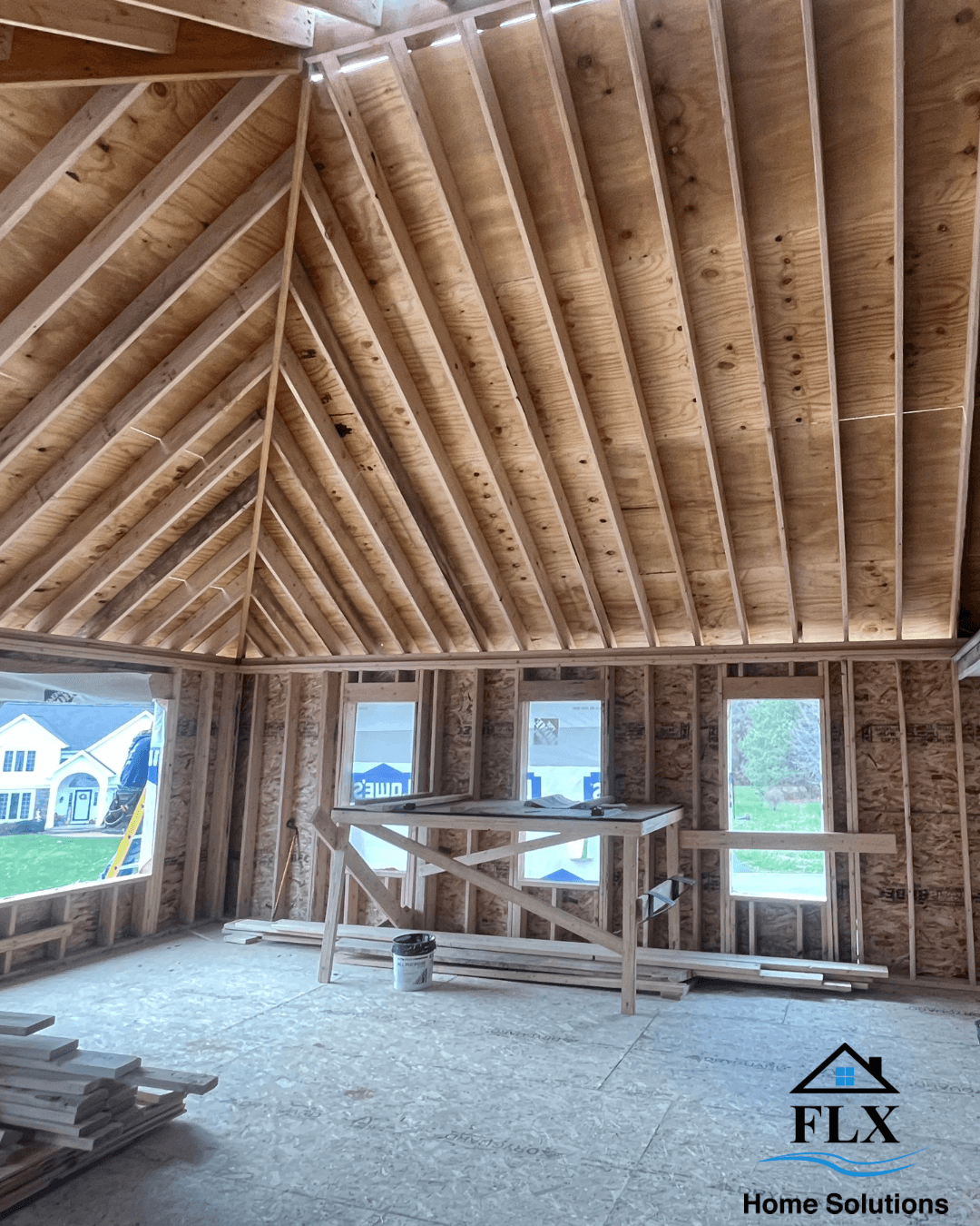 Vaulted ceiling framing in home addition under construction with exposed wood beams