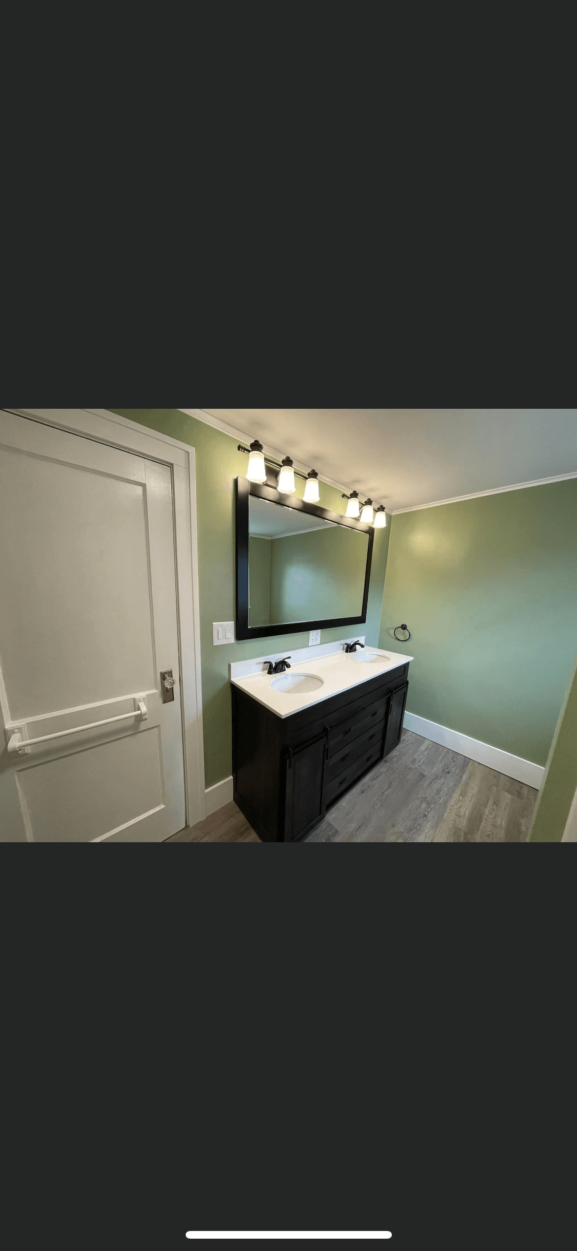 Remodeled bathroom with green walls, dark wood vanity, and white countertop