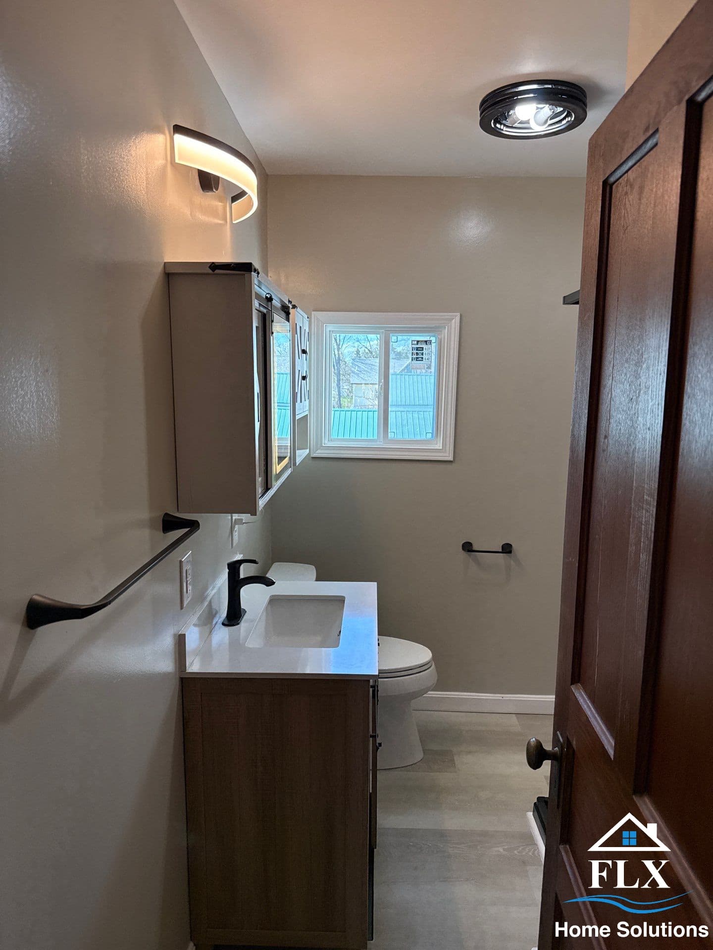 Modern bathroom with dark wood vanity, white countertop, and curved wall sconce