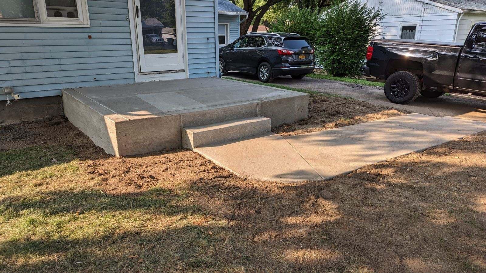 Newly poured concrete porch, steps, and walkway leading to house