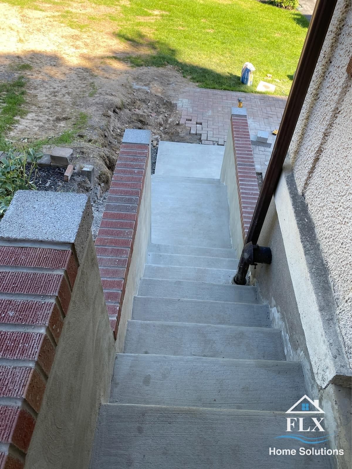 Aerial view of freshly poured concrete stairs leading from upper landing to ground level