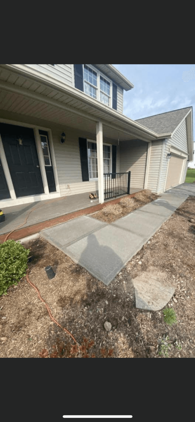 Concrete walkway leading to covered front porch with cream vinyl siding