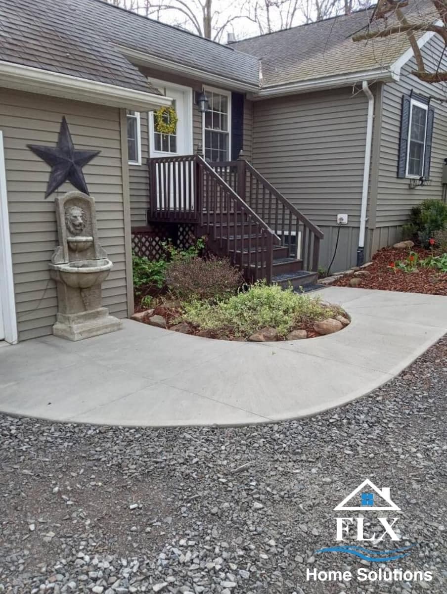 Curved concrete walkway with garden island leading to home entrance with stairs