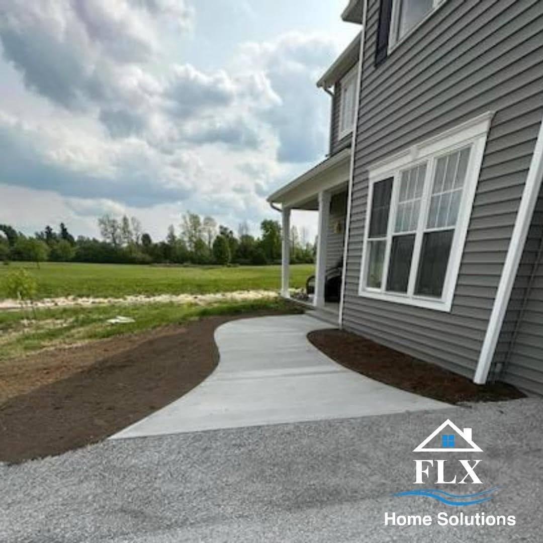 Curved concrete walkway leading to gray house with white trim