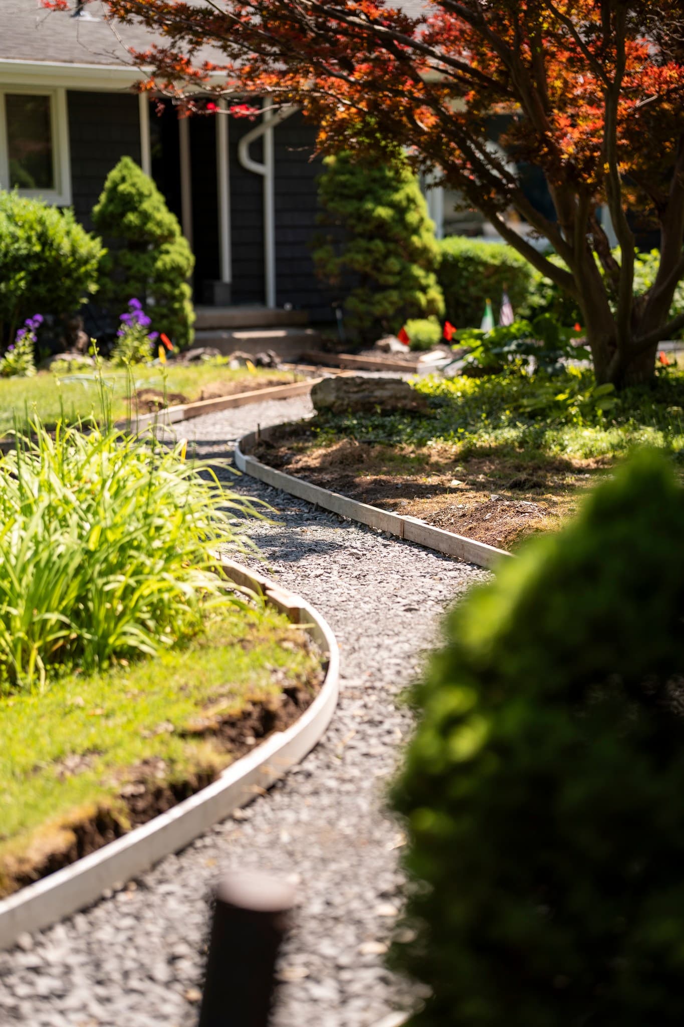 Curved gravel walkway with white edging leading to house entrance