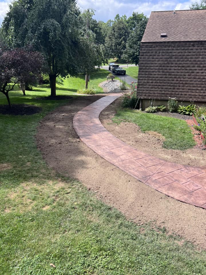 Curved stamped concrete walkway leading from lawn to driveway