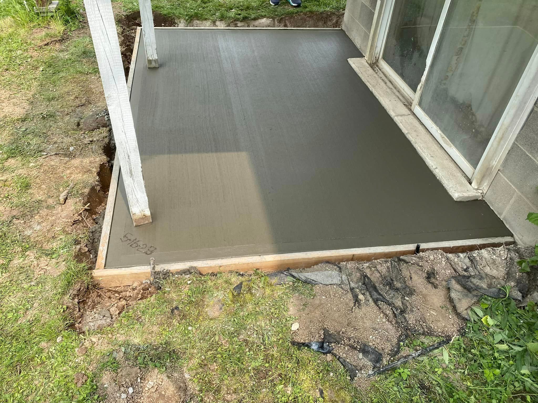 Smooth concrete slab freshly poured at building entrance with wooden forms