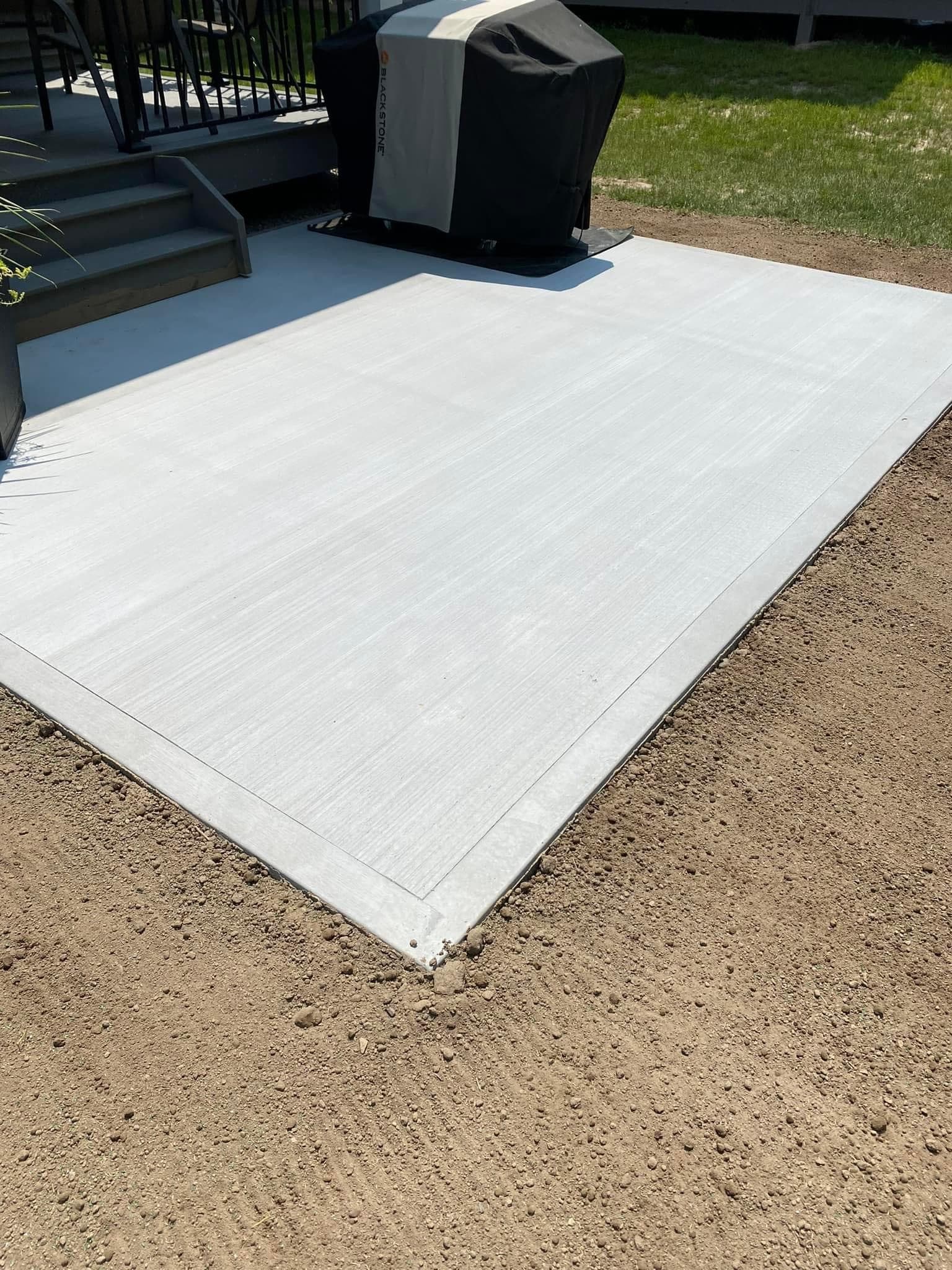 Newly finished concrete patio with smooth textured surface in backyard