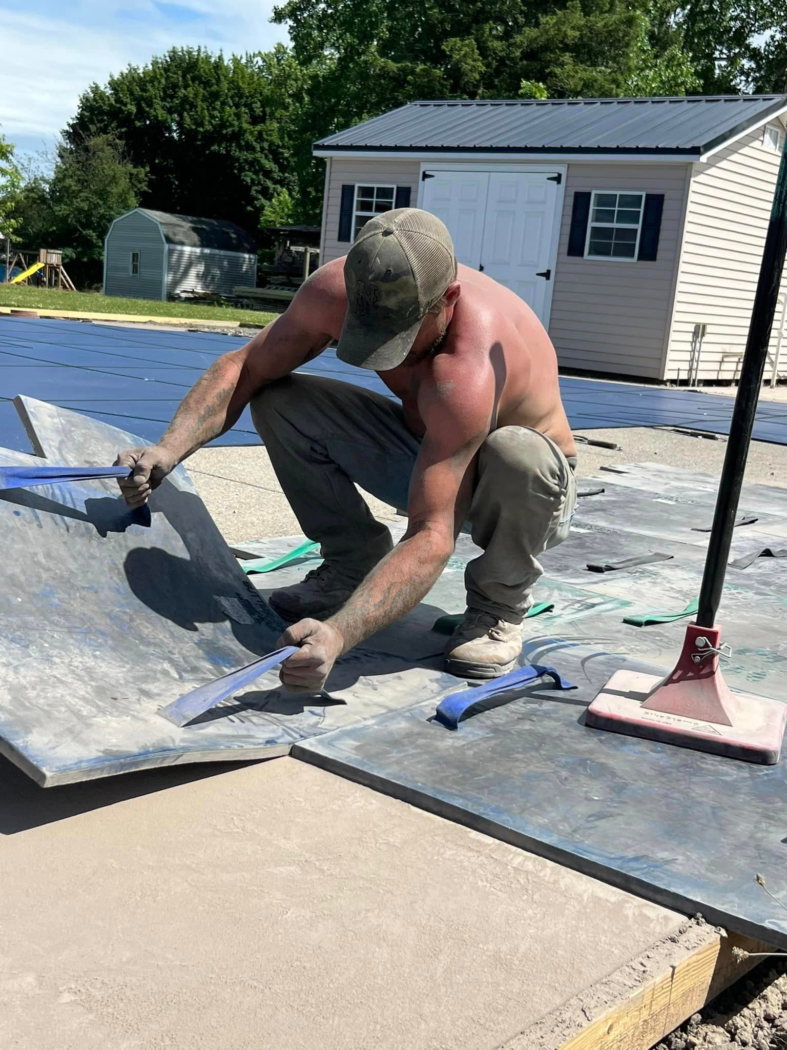 Worker installing metal roofing panels on residential structure