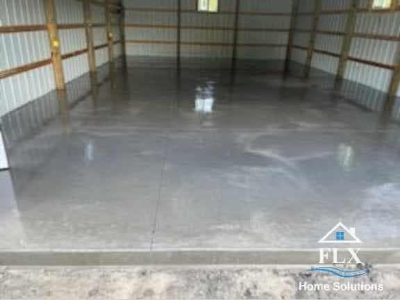 Polished concrete floor in empty garage with metal frame walls