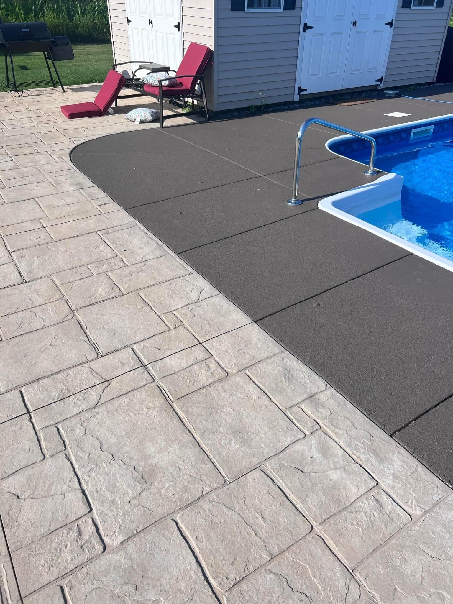 Stamped concrete patio and pool deck with blue swimming pool and lounge chairs
