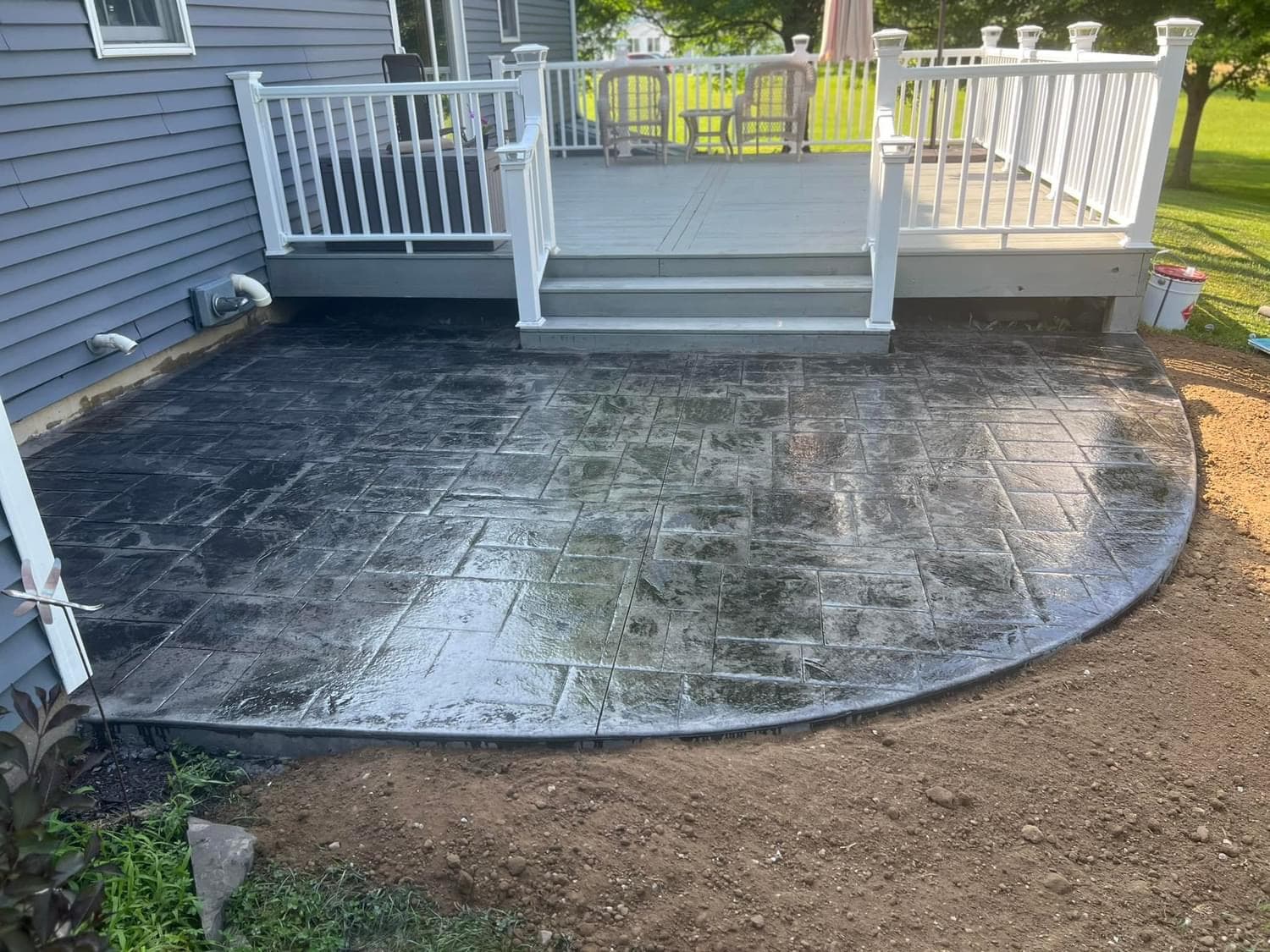 Stamped concrete patio with ashlar slate pattern beneath white deck