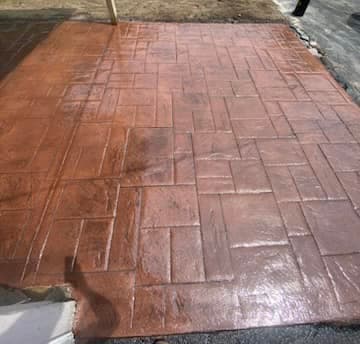 Stamped concrete patio with brick pattern design in brown tones
