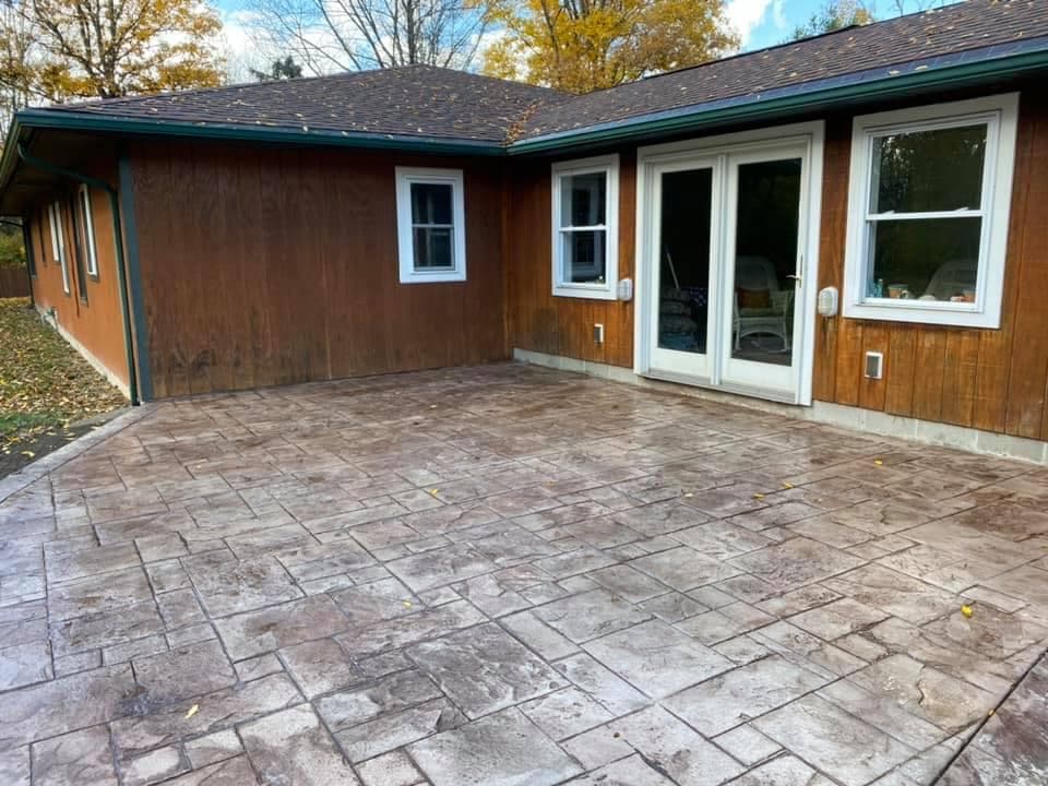 Stamped concrete patio at walkout basement with French doors and wood siding
