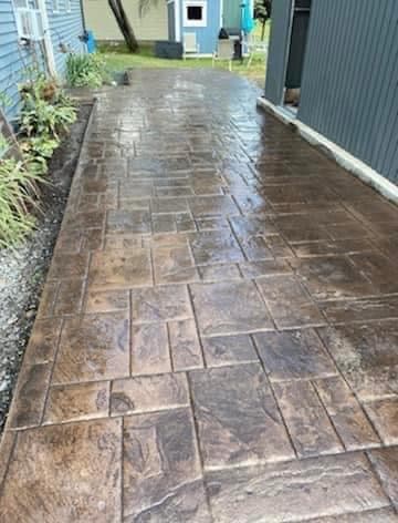 Stamped concrete patio walkway with ashlar slate pattern between two buildings
