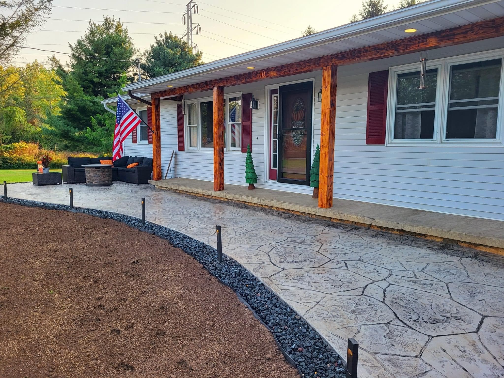 Stamped concrete patio and walkway with decorative wood posts and American flag