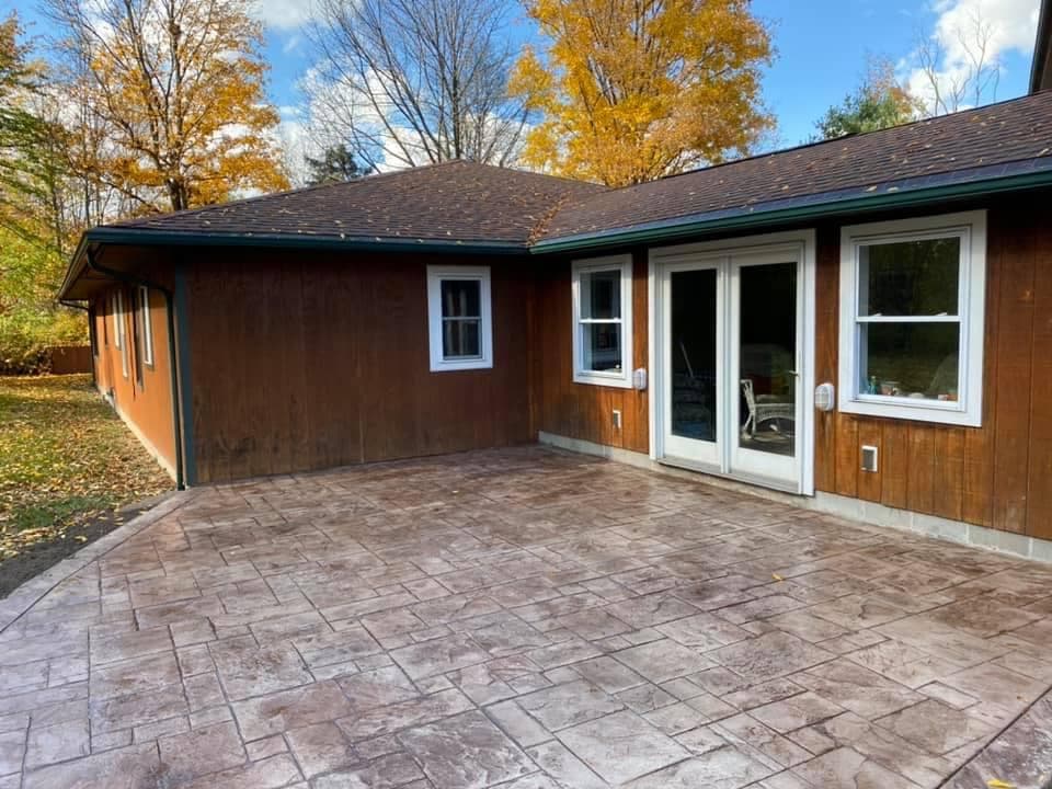 Brown wood-sided home with stamped concrete patio and French doors