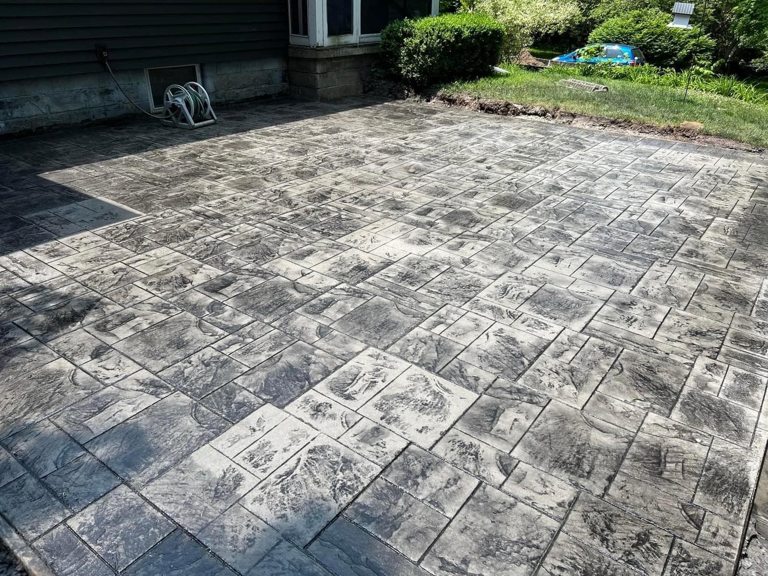 Large stamped concrete patio with aged surface and geometric pattern
