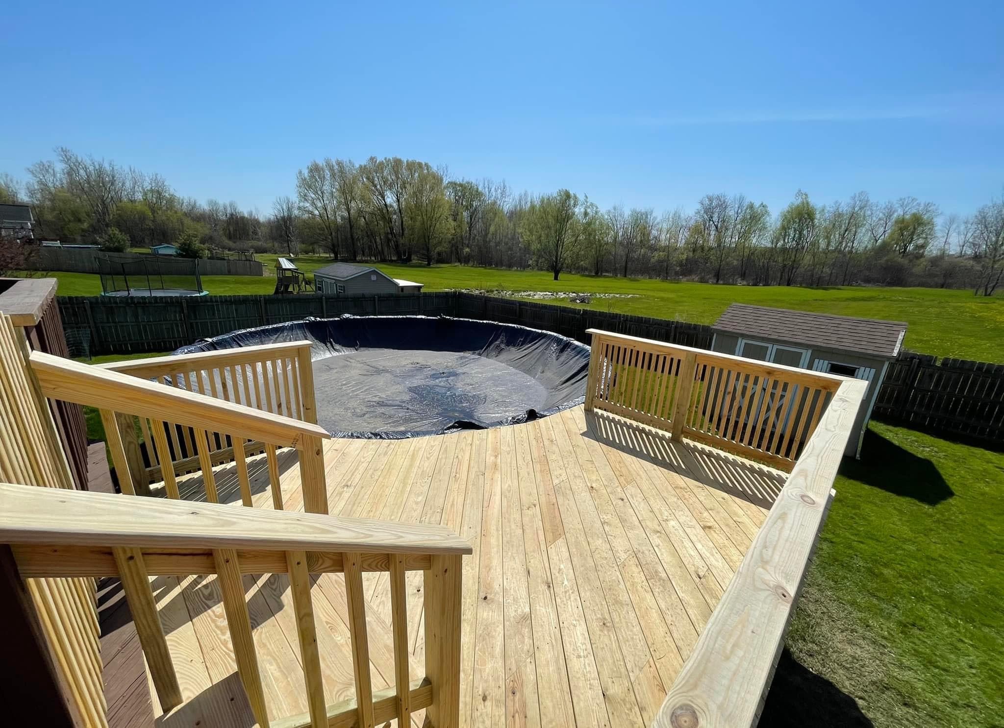 New wooden deck with railings built around an above-ground pool