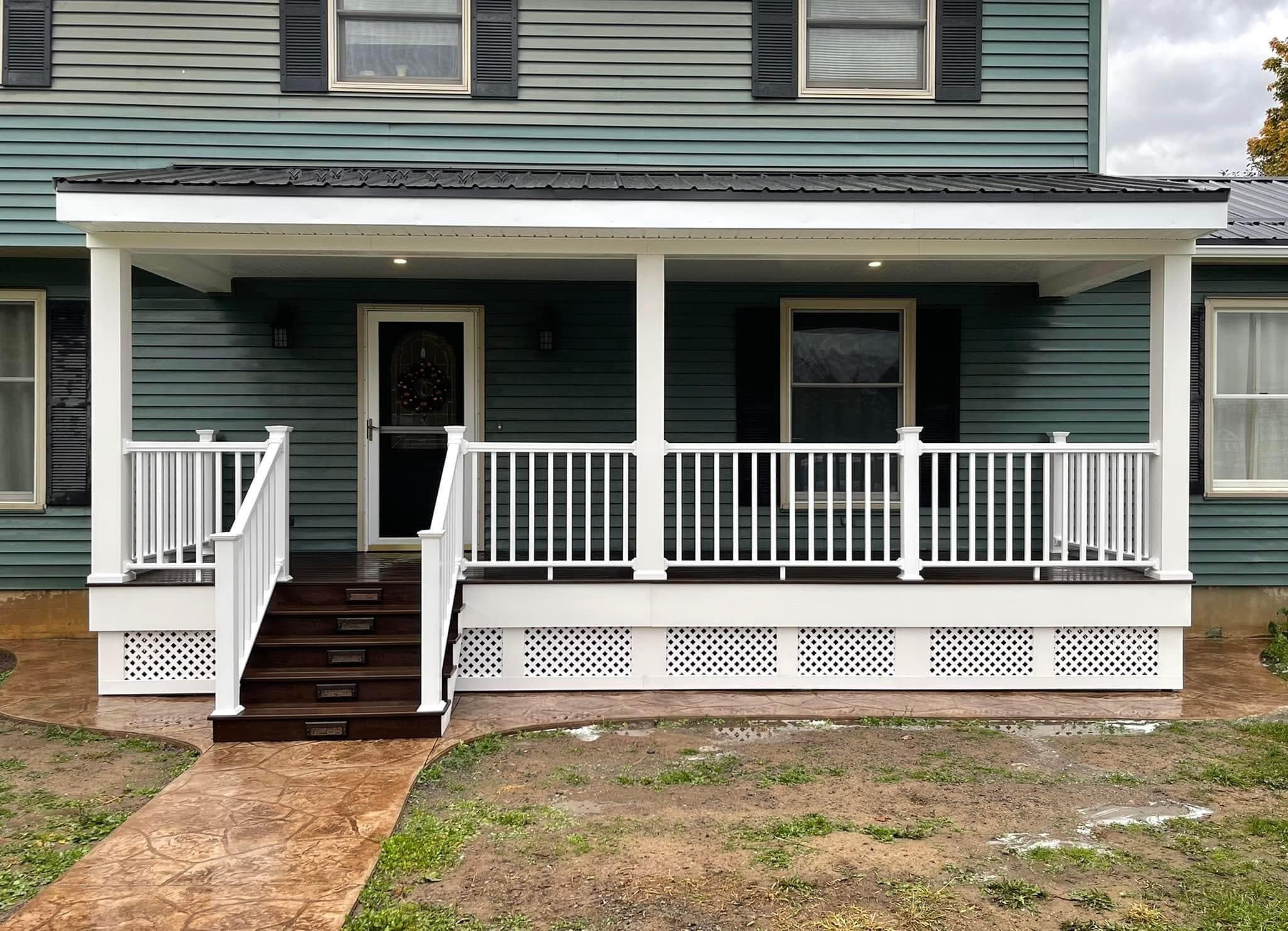 White porch with dark steps and lattice skirting on blue-green house