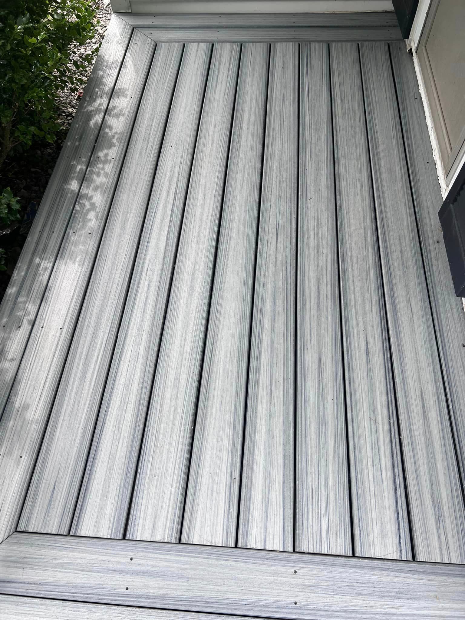 Gray composite deck with parallel boards and wood grain texture
