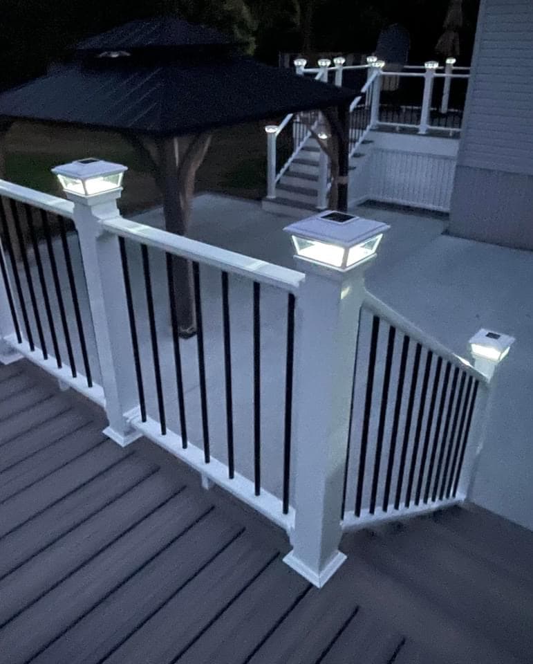 Custom deck with illuminated white post cap lights on railing at night