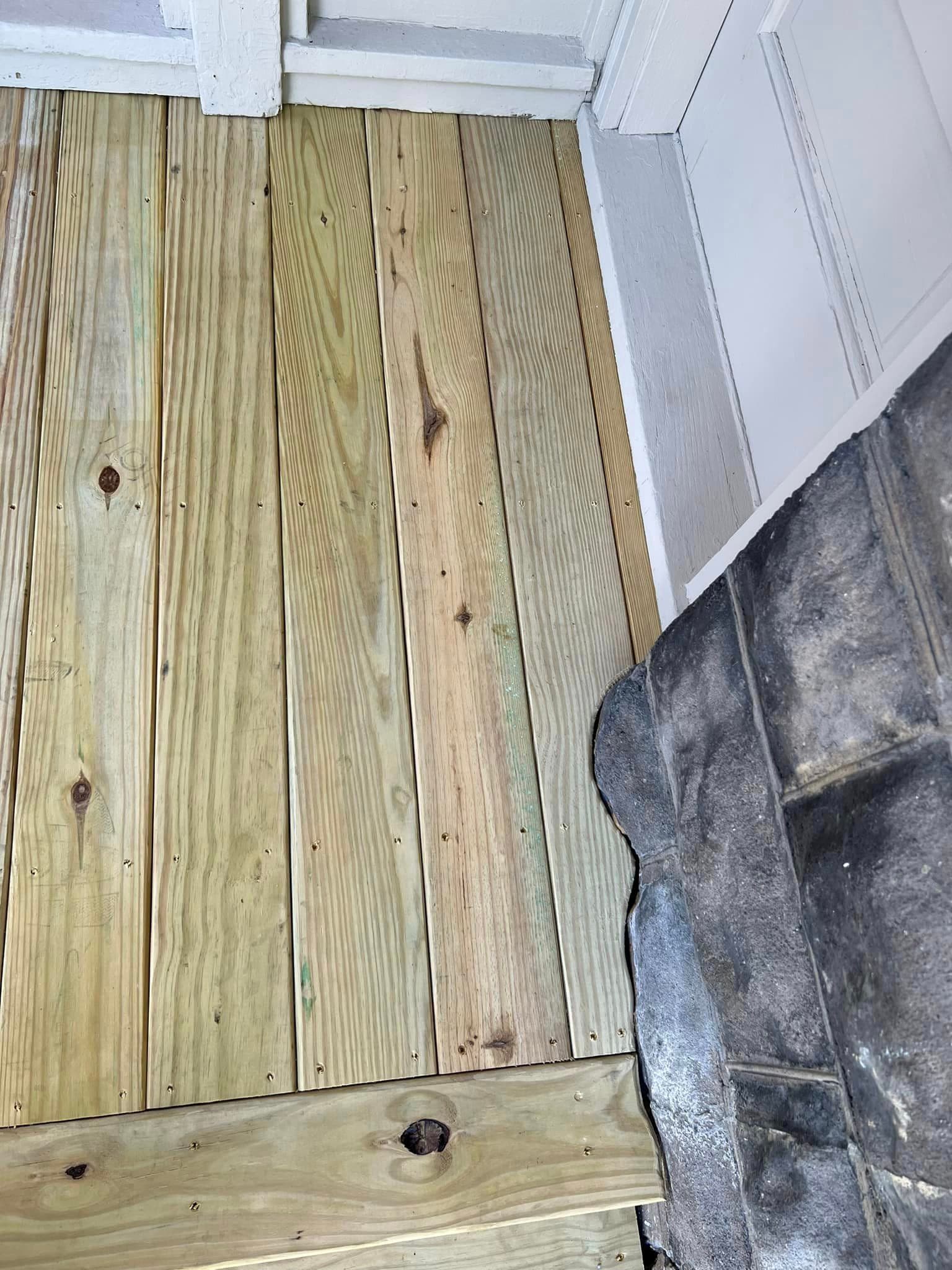 Pressure-treated wood deck boards during construction with white painted trim