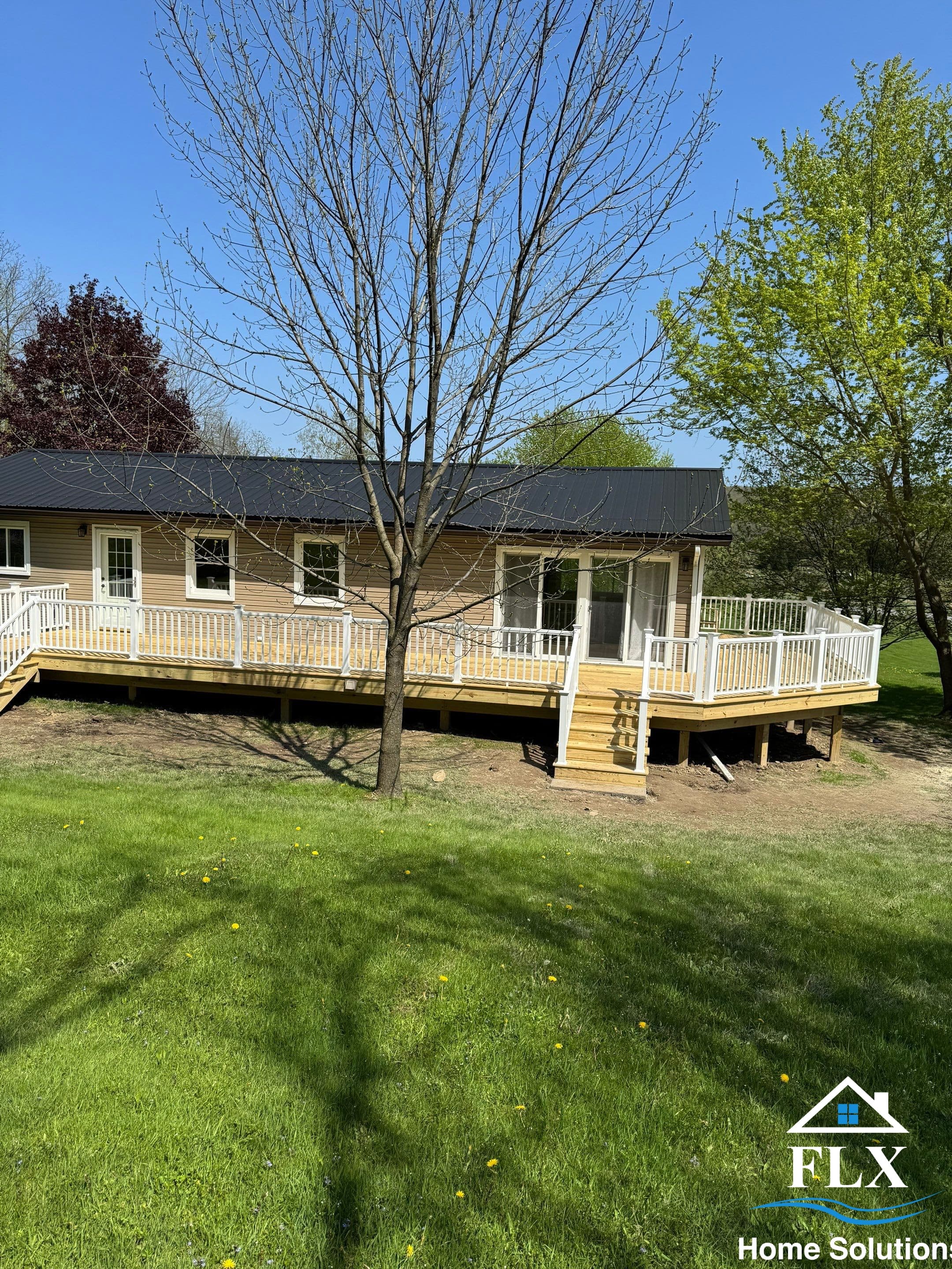 Single-story ranch home with new wraparound wood deck and white railings