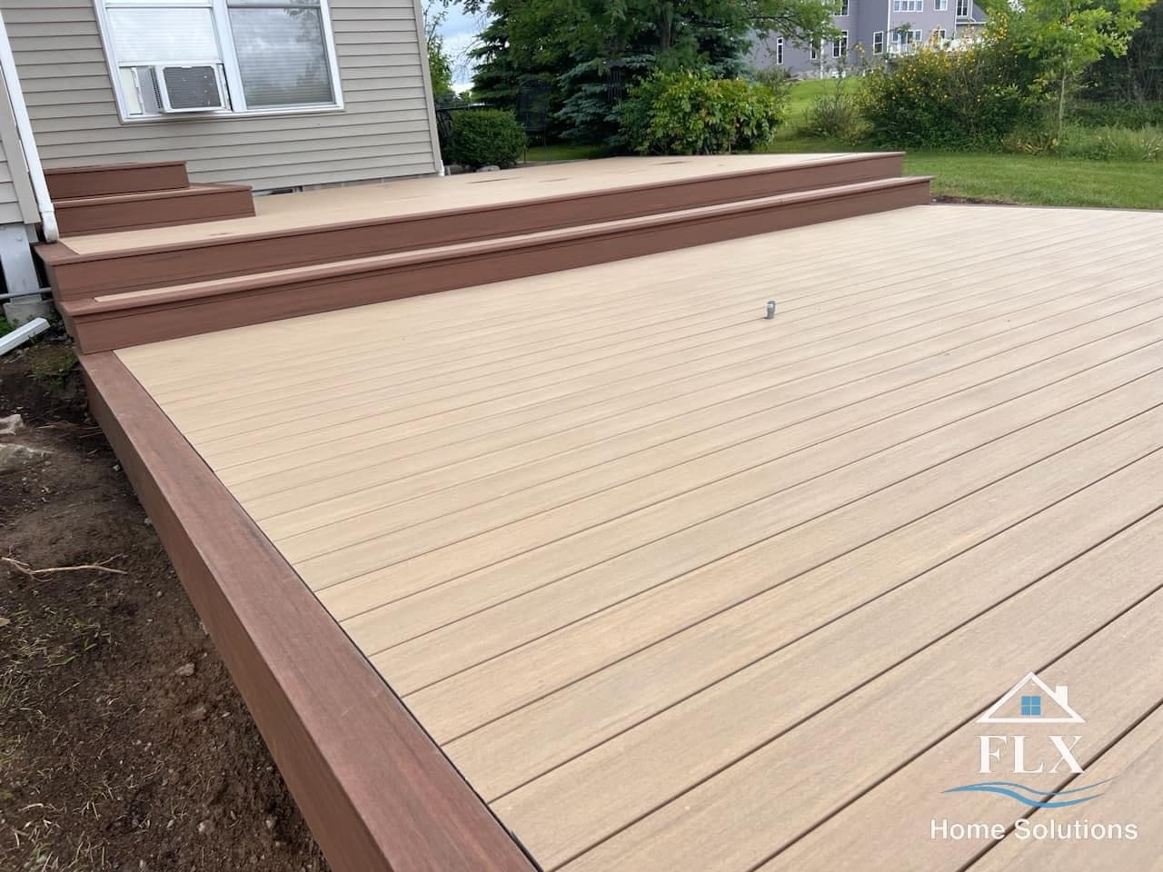 Two-tone composite deck with tan surface and brown border and stairs
