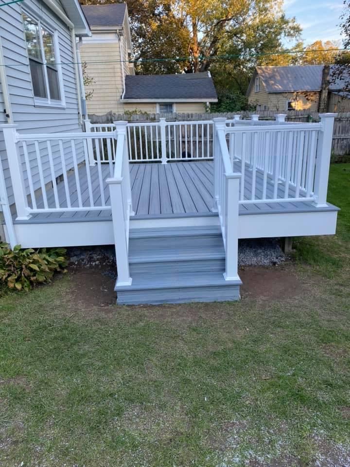 White composite deck with railing and steps attached to house