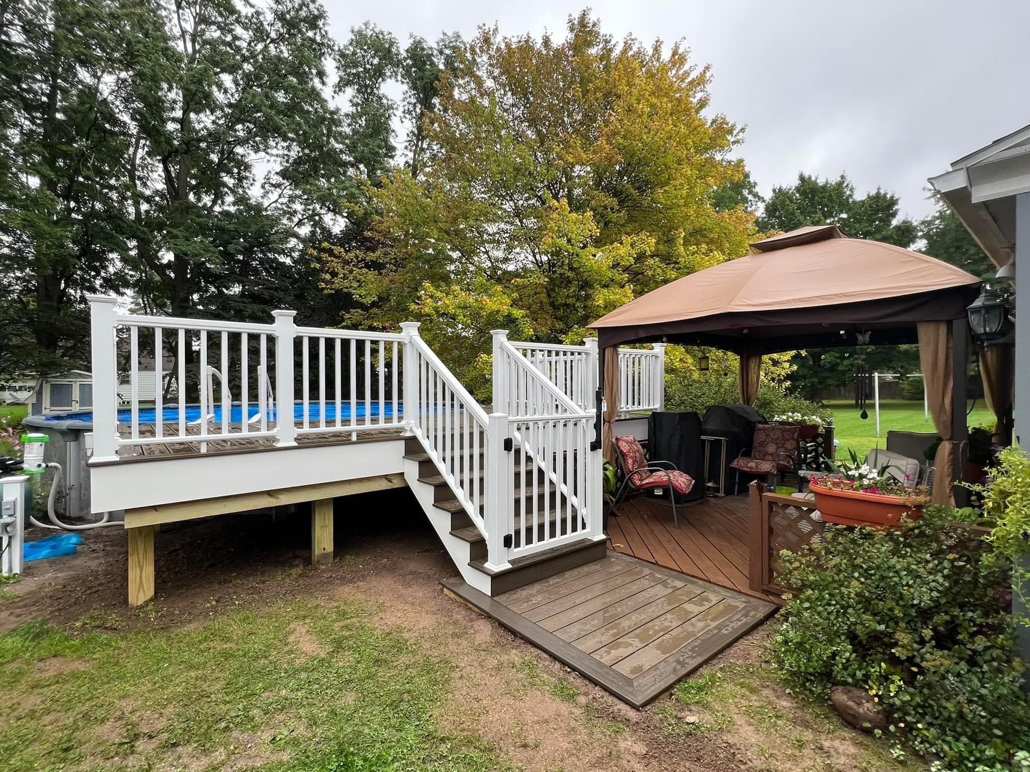 Custom white deck with pool access and covered gazebo seating area
