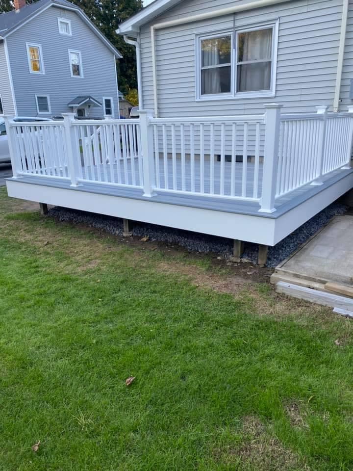 White vinyl deck with vertical railing attached to residential home
