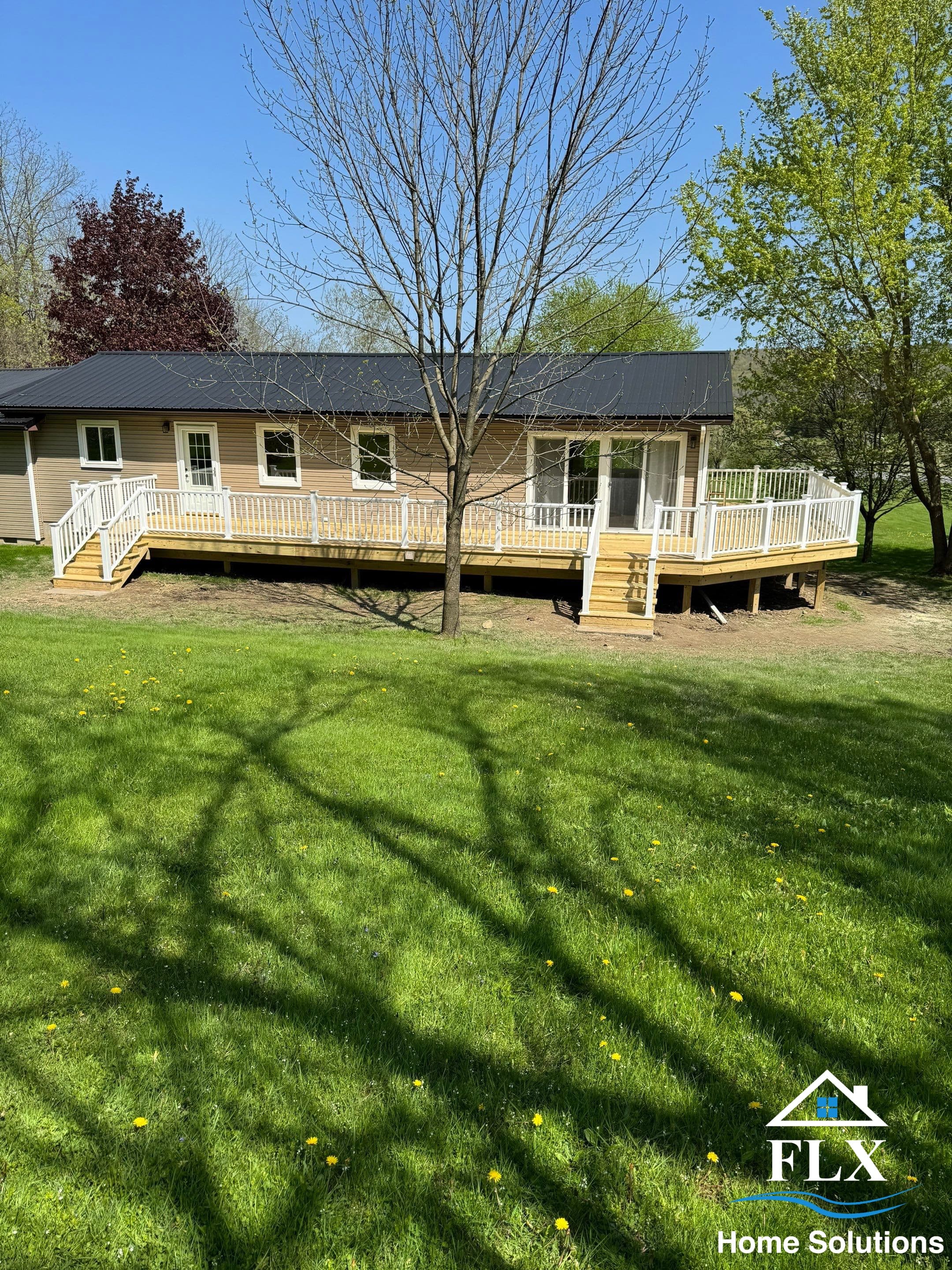 Newly built wraparound deck with white railings and natural wood flooring