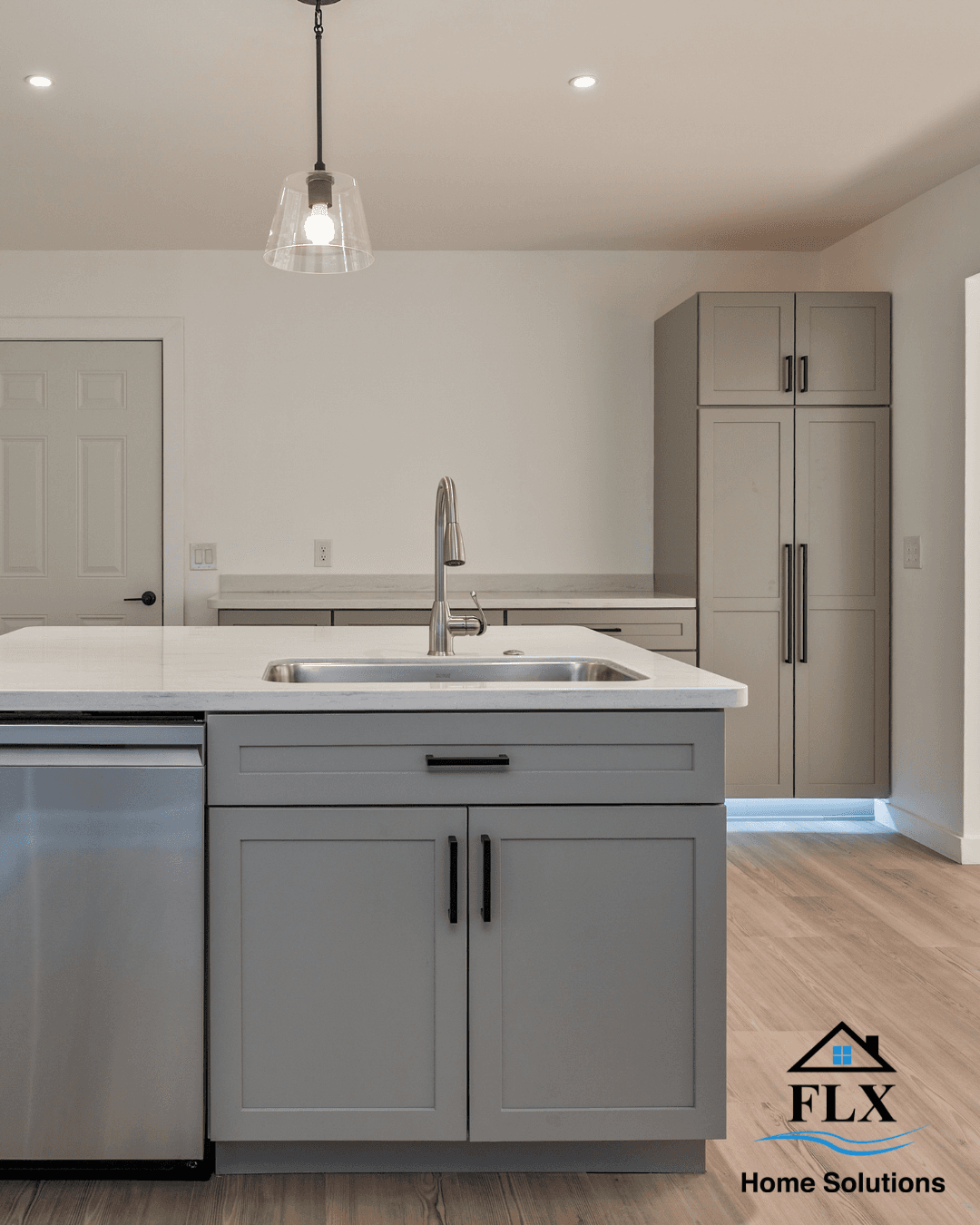 Modern kitchen island with stainless steel sink and white countertop