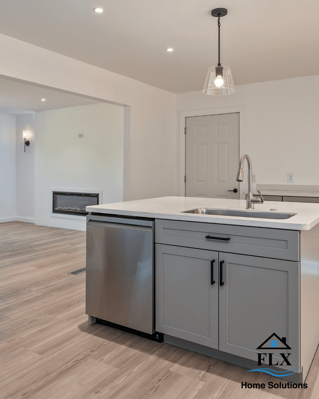 Kitchen island with white countertop, gray cabinets, and stainless dishwasher