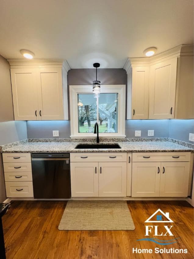 Modern kitchen with white shaker cabinets, granite countertops, and stainless steel sink