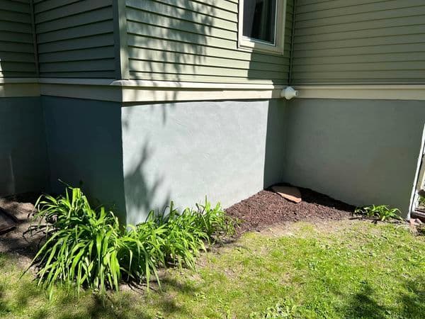 House foundation exposed during excavation or repair work with tarp covering