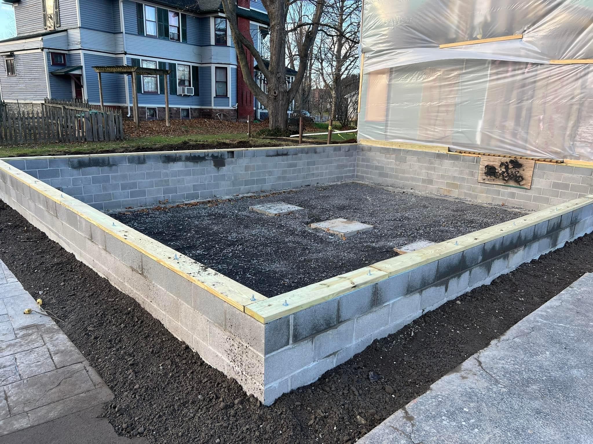 Concrete block foundation with gravel base and wood framing during construction