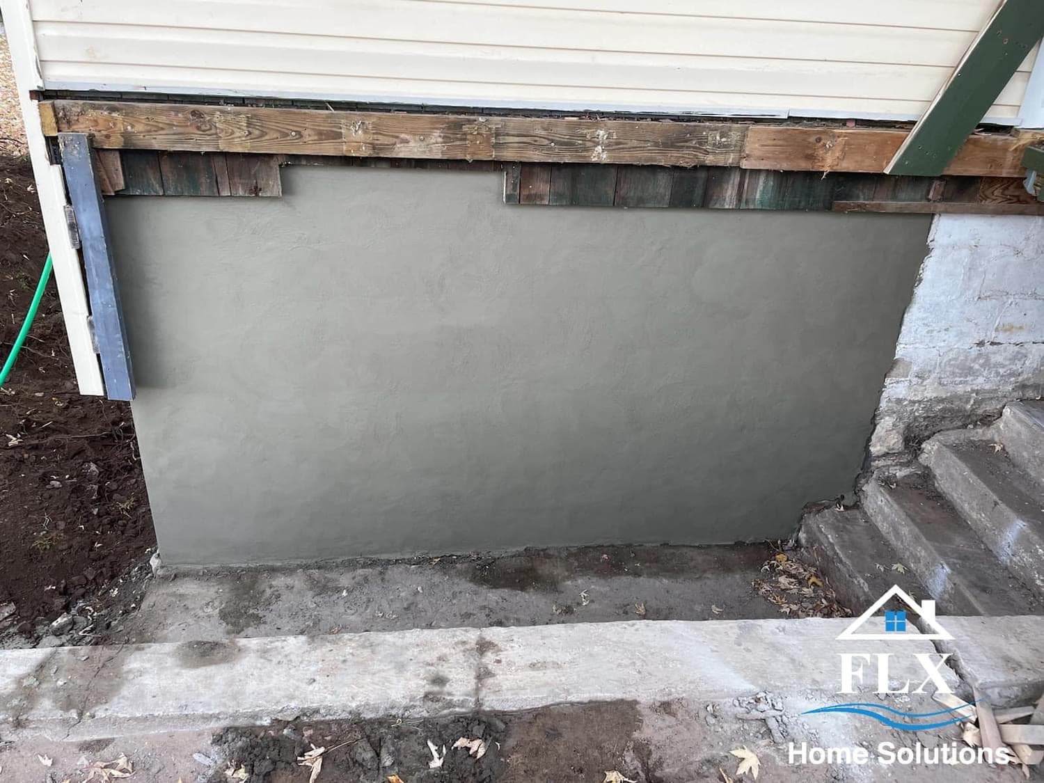 Freshly poured concrete foundation wall with wooden forms and support beams