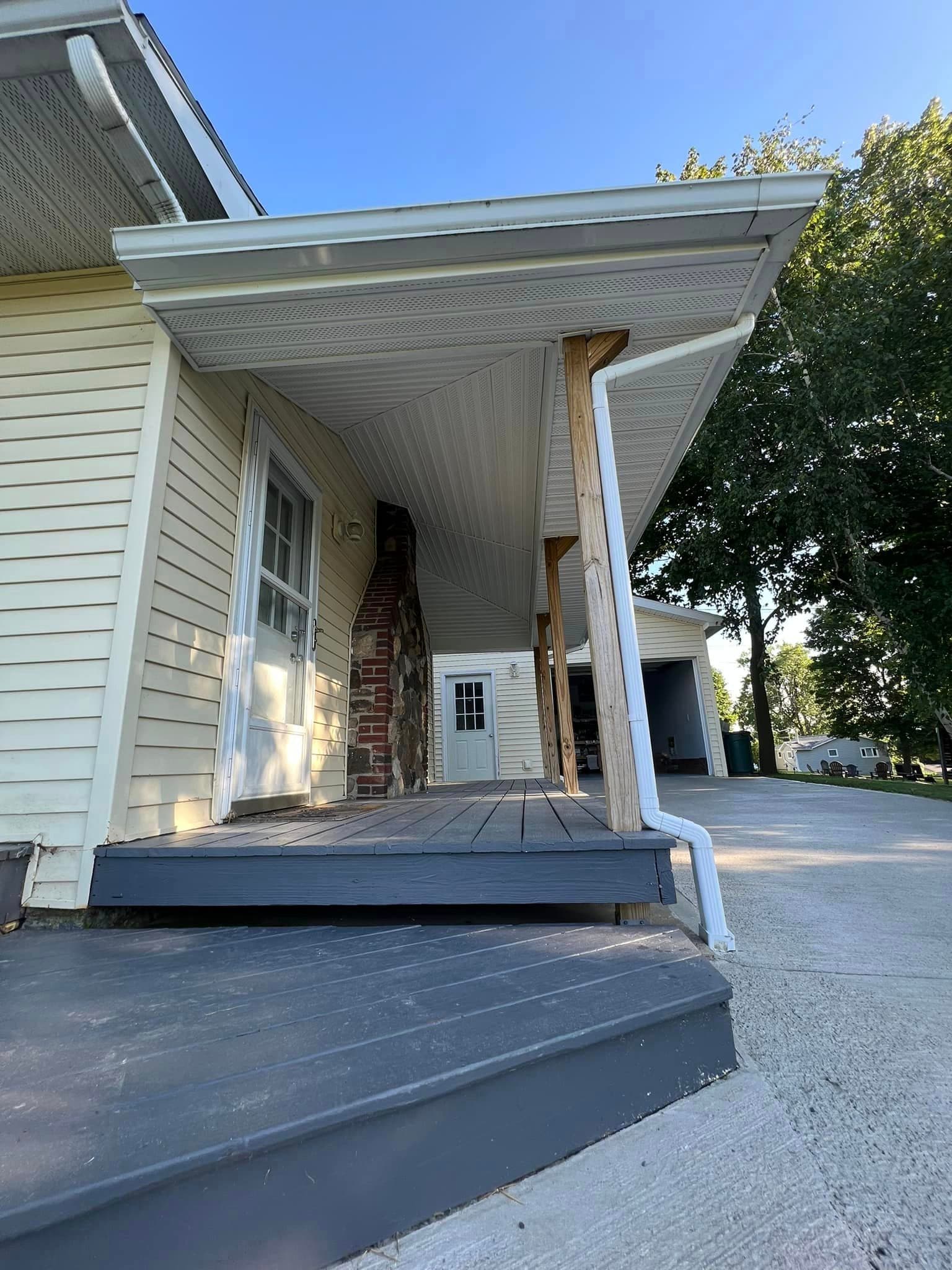 Front porch with white siding, gray wood steps, and covered entryway