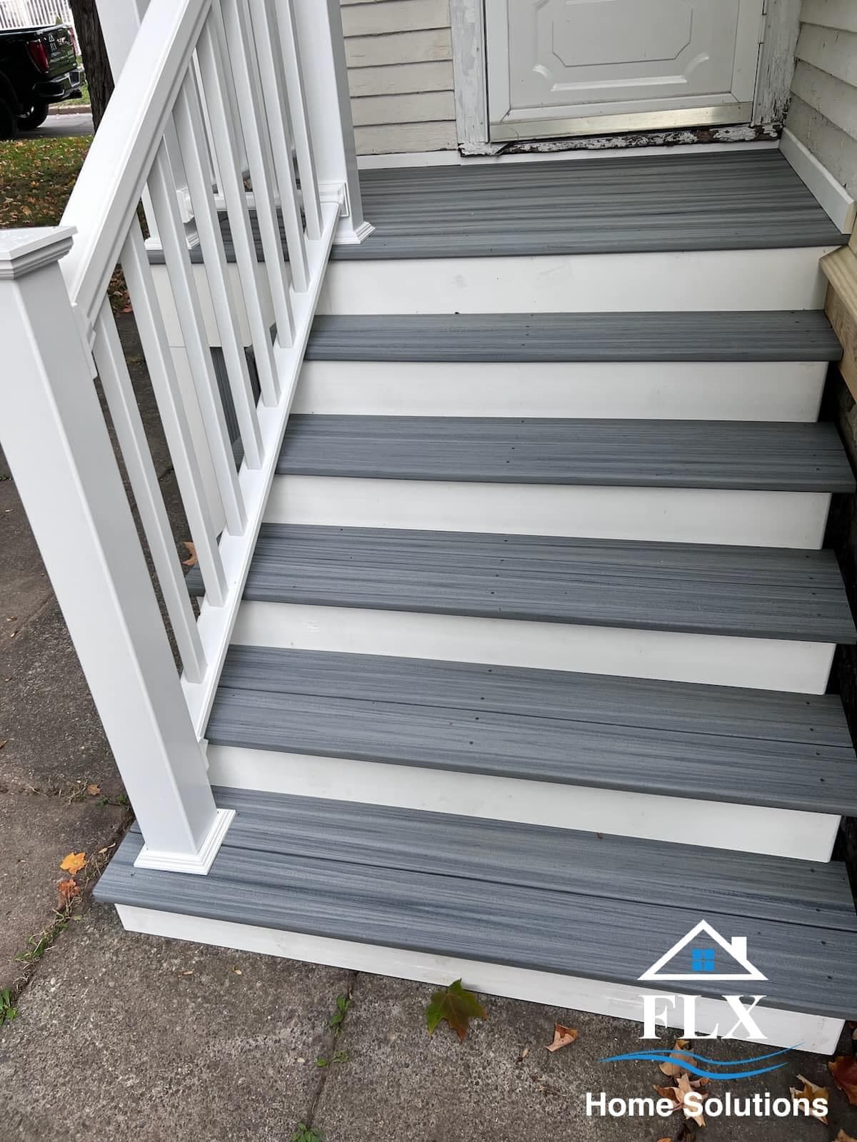 Porch stairs with gray composite treads and white risers leading to front door