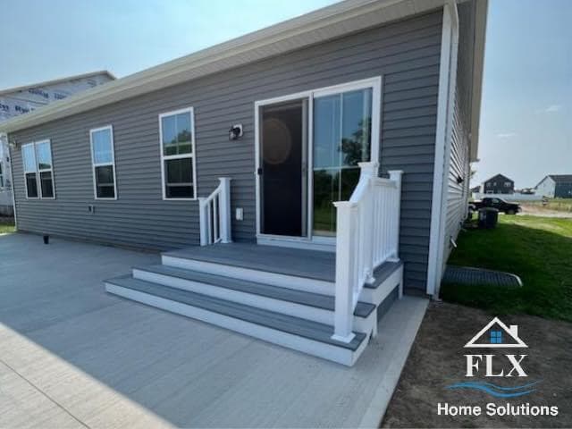 Gray manufactured home with white-trimmed deck and steps leading to entrance