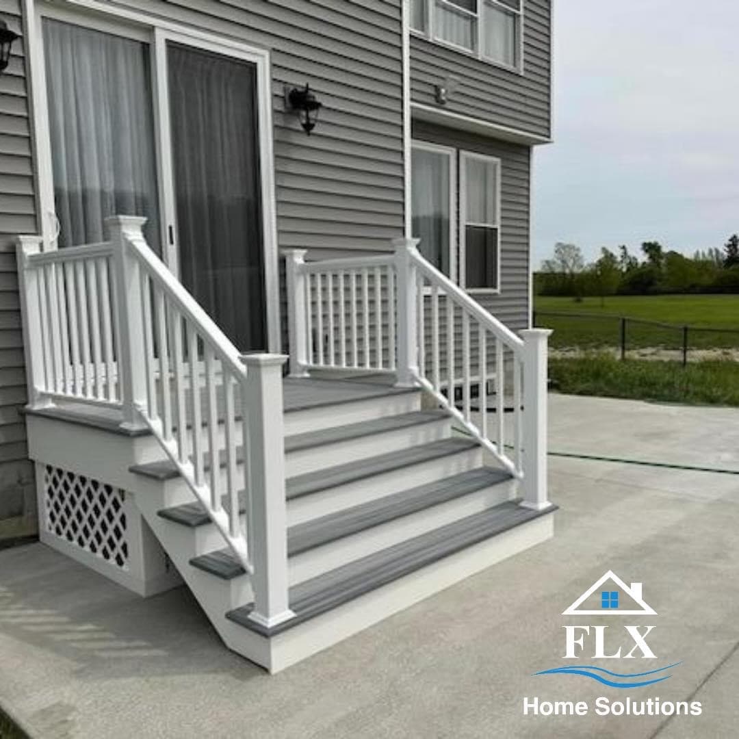 Gray and white porch stairs with white railings and lattice skirting