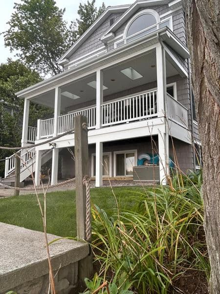 Two-story Victorian home with white wraparound porch and ornate gable trim