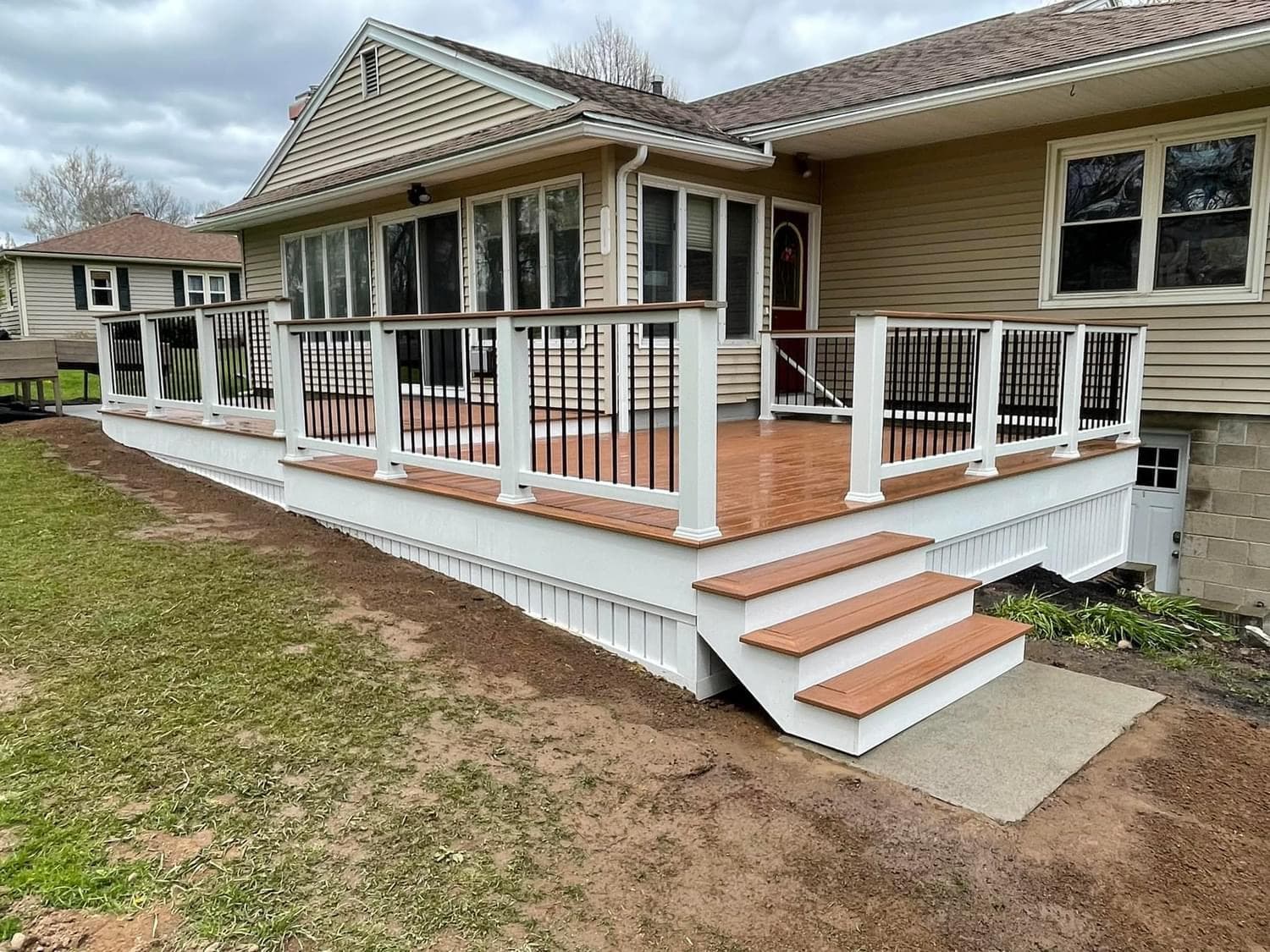Screened porch with white railings and wood deck stairs