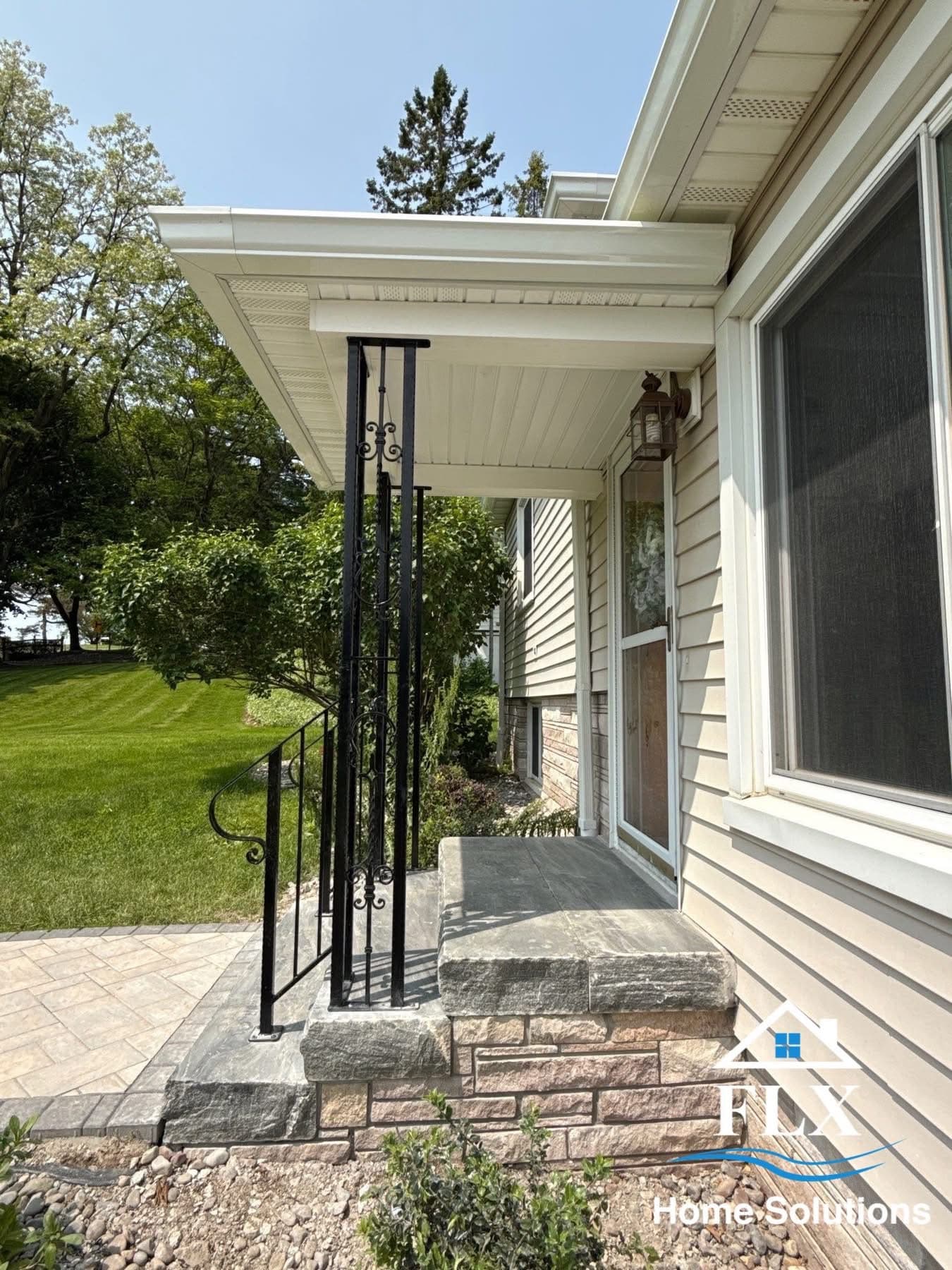Front entrance with stone steps and decorative black metal railing