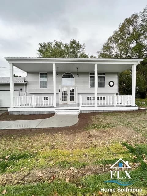 White mobile home with covered front porch and white railings