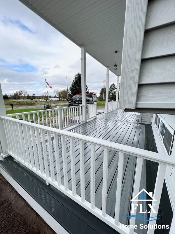 White-painted porch with railings and columns overlooking neighborhood